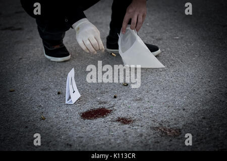 La scène du crime, le meurtre, l'enquête, les manches des coups de servir de preuve, l'enquête est terminée, l'expert prend la capsule des forceps et placés dans Banque D'Images