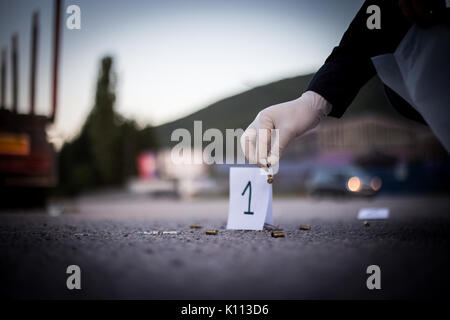 La scène du crime, le meurtre, l'enquête, les manches des coups de servir de preuve, l'enquête est terminée, l'expert prend la capsule des forceps et placés dans Banque D'Images