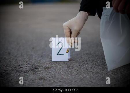La scène du crime, le meurtre, l'enquête, les manches des coups de servir de preuve, l'enquête est terminée, l'expert prend la capsule des forceps et placés dans Banque D'Images