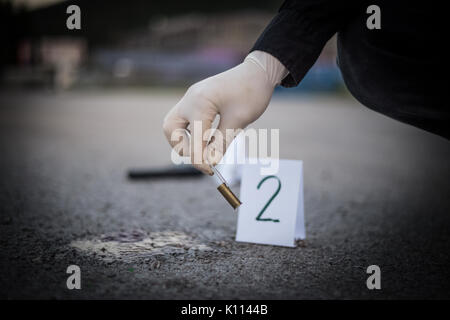 La scène du crime, le meurtre, l'enquête, les manches des coups de servir de preuve, l'enquête est terminée, l'expert prend la capsule des forceps et placés dans Banque D'Images