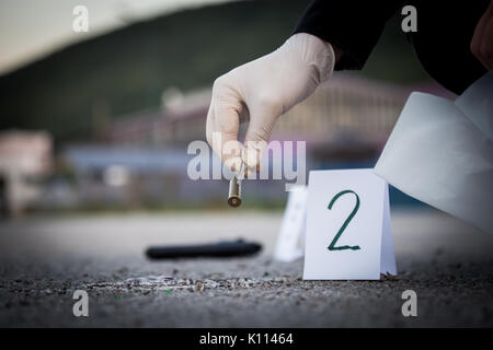 La scène du crime, le meurtre, l'enquête, les manches des coups de servir de preuve, l'enquête est terminée, l'expert prend la capsule des forceps et placés dans Banque D'Images