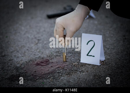 La scène du crime, le meurtre, l'enquête, les manches des coups de servir de preuve, l'enquête est terminée, l'expert prend la capsule des forceps et placés dans Banque D'Images