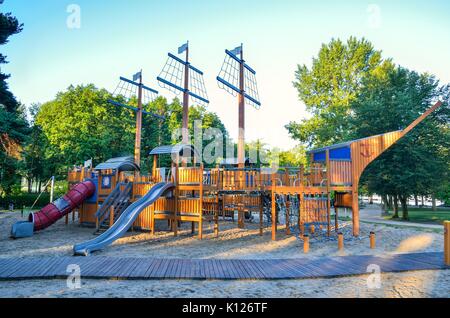 Belle aire de jeux pour enfants sur le lac. Aire de jeux en bois en forme de navire. Banque D'Images