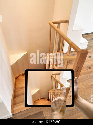 Appareil mobile avec l'homme en tenant les mains photo sur le bois dur et la rampe escalier Banque D'Images