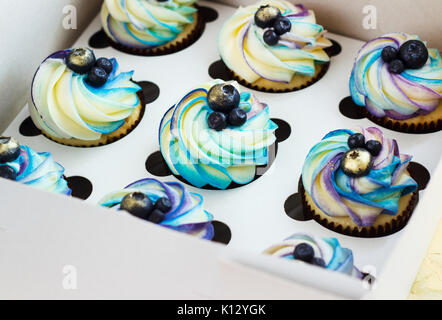Cupcake doux avec de la crème et les baies dans la boîte. Banque D'Images