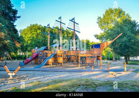 Belle aire de jeux pour enfants sur le lac. Aire de jeux en bois en forme de navire. Banque D'Images