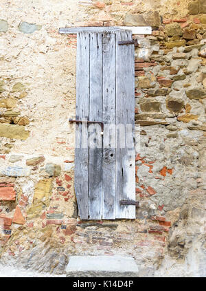 Vieille porte en bois sur mur de pierre Banque D'Images