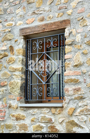 Fenêtre avec grille en fer sur mur de pierre Banque D'Images