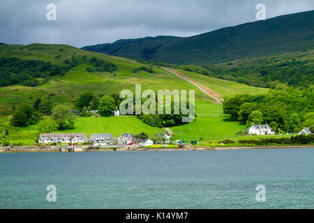 Paysage avec village de Colintraive au pied des collines d'emerald fields & woodlands & sur le rivage de Kyles de Bute, vu de l'île de Bute, Ecosse Banque D'Images