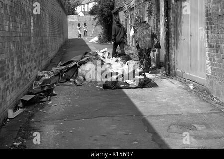 24 août 2017 - Les jeunes femmes en passant devant les détritus et les faisant basculer dans une ruelle contre Cardiff Banque D'Images