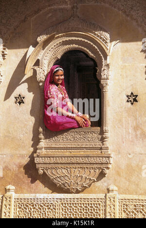 Femme assise à la fenêtre de Patwon-ki-Haveli (Maison des marchands de brocart), Jaisalmer, Rajasthan, India Banque D'Images