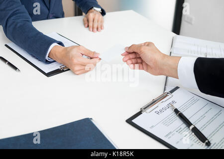 Jeune homme d'affaires à l'entrevue d'embauche dans le bureau, réunion au hall de l'office, l'évolution des cartes d'affaires Banque D'Images