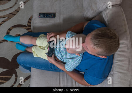 Enfant Garçon et son père jouer avec une playstation ensemble. Banque D'Images