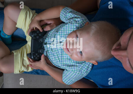 Enfant Garçon et son père jouer avec une playstation ensemble. Banque D'Images