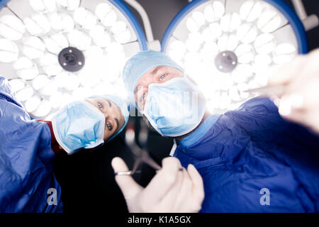 Fonctionnement de l'équipe de chirurgiens Chirurgie patient sous l'éclairage de l'hôpital. Médecins pratiquant la chirurgie dentaire. Banque D'Images