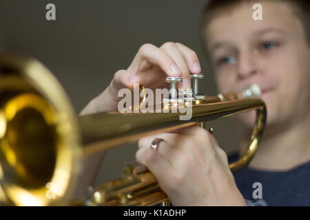Jeune garçon pratiquant la trompette. Banque D'Images