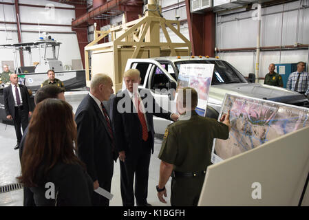 Le Président américain Donald Trump, centre, et chef de cabinet de John Kelly, gauche, sont donnés une séance d'information sur le mur de la frontière par le chef du Secteur des prototypes Yuma Agent Patrol Anthony Porvaznik, droite, au cours d'une visite à la station de patrouille à la frontière de Yuma, le 22 août 2017 à Yuma, Arizona. Banque D'Images