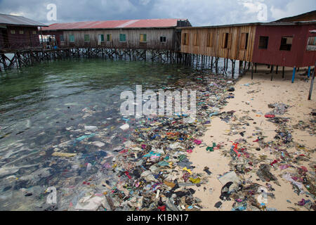 Déchets en plastique et autres déchets couvre une plage en face des stations de plongée sur l'île de Mabul, Bornéo Banque D'Images