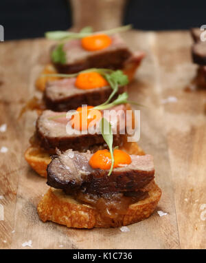 Planche à découper en bois avec filet de boeuf avec oeuf hors d'oeuvres Banque D'Images