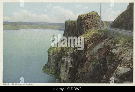 Une carte postale créée à partir d'une photographie, montre une vue sur le lac Rock, un passage pour les voies de train est coupé à travers la montagne sur le côté droit de la photo, campagne non peuplée peut être vu en arrière-plan, Washington State, 1914. De la bibliothèque publique de New York. Banque D'Images