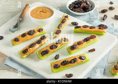 Des fourmis sur un journal Snack avec du beurre d'arachides et raisins Céleri Banque D'Images