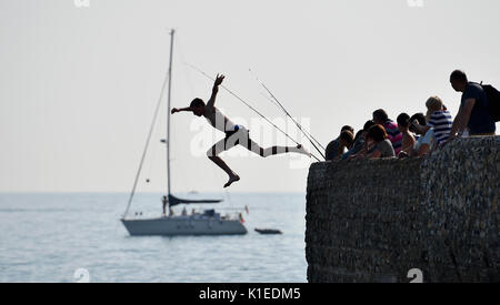 Brighton, UK. Août 27, 2017. Jeunes bond dans le mer à partir d'un épi sur la plage de Brighton autrement connu sous le nom de désactivation dans le bain de soleil aujourd'hui que les températures devraient atteindre 28 degrés au cours du week-end de la banque qui est un record pour le mois d'août . Les sauveteurs locaux et garde-côtes avertissent que désactivation peut être très dangereux car leur a eu de nombreux accidents ces dernières années de crédit : Simon Dack/Alamy Live News Banque D'Images