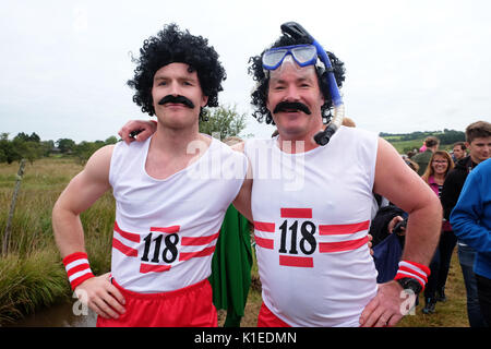 Championnat du Monde de plongée tourbière, Llanwrtyd Wells, Powys, Wales, UK - Août 2017 - Deux concurrents habillé comme le '118118' caractères - les concurrents de la plongée vers le haut et l'arrière le long d'une tranchée de 60 yards à travers une tourbière dans le temps le plus rapide possible, l'événement annuel a lieu à l'Waen Rhydd tourbière de Llanwrtyd Wells. Crédit : Steven Mai/Alamy Live News Banque D'Images