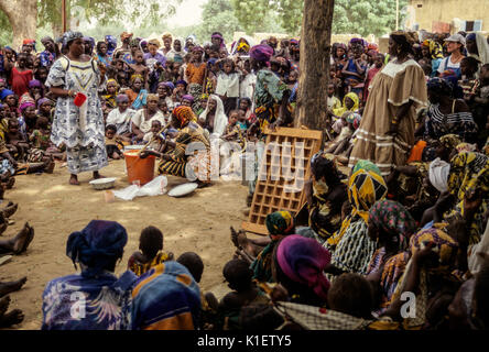 Le Niger, Ouna Village, Afrique de l'Ouest. Démonstration de fabrication de savon. (Zarma Djerma) groupe tribal. Deux volontaires du Corps de la paix sont dans la foule. Banque D'Images