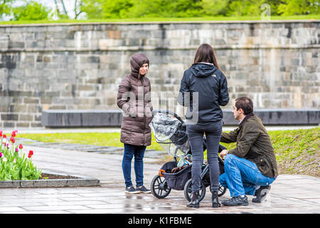 La ville de Québec, Canada - 30 mai 2017 : les familles avec enfants et poussette en parlant avec des amis dans le parc au cours de jour de pluie Banque D'Images