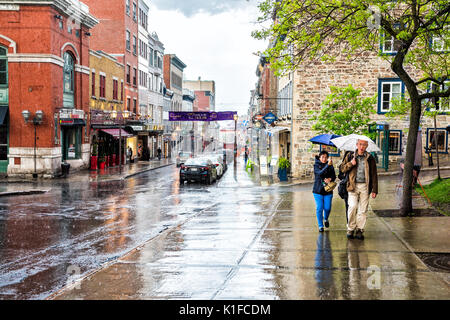 La ville de Québec, Canada - 31 mai 2017 : rue de la vieille ville Saint-Jean lors de fortes pluies avec des gouttes et route mouillée par les restaurants et les gens qui marchent avec umbrel Banque D'Images