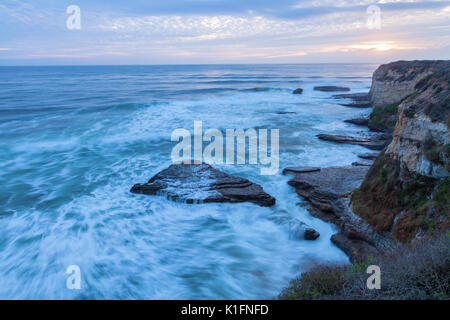 Les vagues qui s'affrontent le long de la côte de Californie à Santa Cruz au coucher du soleil sur une journée à la fin de l'automne. Banque D'Images