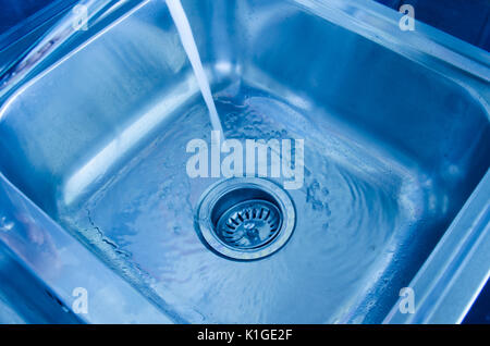 Évier, laver la vaisselle, l'eau coule du robinet. Banque D'Images