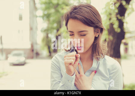 Jeune femme ayant d'asthme ou de suffocation ne peuvent pas souffrir de problèmes de respiration la respiration debout à l'extérieur sur une rue urbaine Banque D'Images