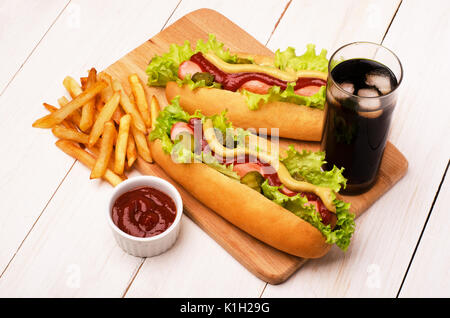 Hot-dogs grillés à la moutarde, ketchup avec verre de cola et de frites sur une table de pique-nique Banque D'Images