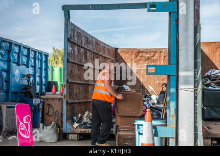 Un employé de vider un wheely bin lors d'un conseil municipal de recyclage / centre / refuser astuce en Bourne, Lincolnshire, Angleterre, Royaume-Uni. Banque D'Images