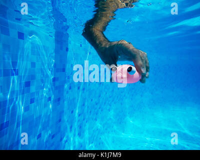 L'homme jouant avec les poissons en caoutchouc générique jouet en piscine, activité d'été et la jouissance, underwater Banque D'Images