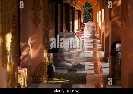 Deux hommes plongés dans la méditation sous des tentes dans Pa-Auk-Tawya monastère près de Mawlamyine, l'État Môn, Myanmar. Banque D'Images