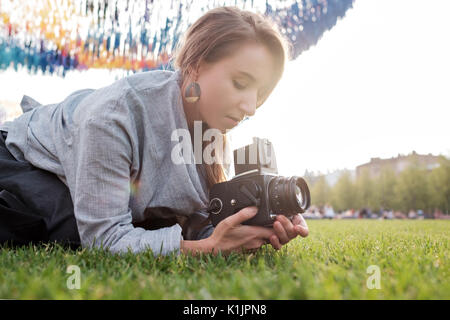 Pretty caucasian female film photocamera. Voyageant woman taking photo sur vintage camera outdoor en été Banque D'Images