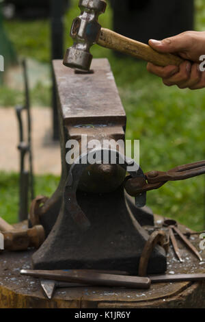 Maréchal-ferrant produisant des fers de la méthode traditionnelle sur une enclume. Banque D'Images