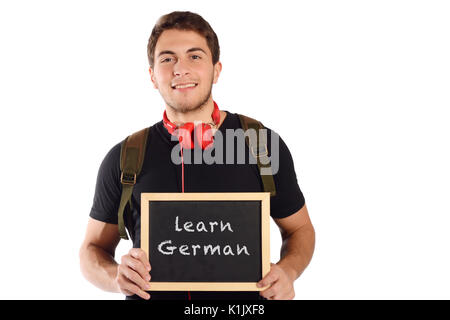 Close up of a young man holding tableau sur lequel un texte 'apprendre l'allemand". L'éducation et langues étrangères concept. Isolé sur fond blanc. Banque D'Images