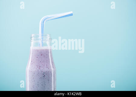 Vue rapprochée de délicieux milk-shake fruité dans le flacon en verre avec paille Banque D'Images