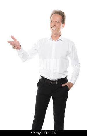 Happy middle aged businessman dans l'usure formelle présenter quelque chose et à l'écart isolated on white Banque D'Images