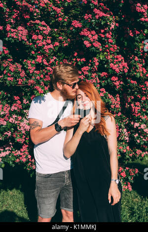 Couple in park eating ice cream cones, posant sur l'appareil photo Banque D'Images