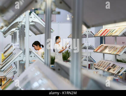 (170827) -- BEIJING, le 27 août 2017 (Xinhua) -- les gens choisir des livres au cours de la 24e Foire internationale du livre de Beijing à Beijing, capitale de Chine, le 27 août, 2017. Les 5 jours juste terminé le Dimanche à Beijing. Selon les organisateurs, 89 pays et régions ont participé à l'exposition. (Xinhua/Shen Hong) (xzy) Banque D'Images