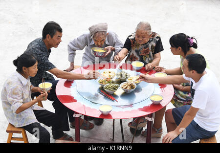 Fengjie, municipalité de Chongqing en Chine. Août 23, 2017. Xiang Yongshan (3L) et son épouse Wu Xi'an (3e R) repas avec les membres de la famille ont en Zaojiao village de Fengping Township, comté de Fengjie, dans le sud-ouest de la municipalité de Chongqing en Chine, le 23 août, 2017. Les 100 ans de Xiang et 101 ans, Wu a été marié pendant 81 ans. Credit : Wang Quanchao/Xinhua/Alamy Live News Banque D'Images