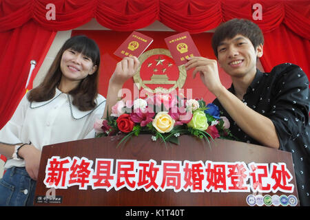 Yuncheng, la province de Shanxi. Août 28, 2017. Un jeune couple de poser pour des photos avec leurs certificats de mariage au bureau d'enregistrement des mariages dans le Xinjiang Comté de Diamond City, au nord la province de Shanxi, le 28 août 2017. De nombreux couples ont choisi de se marier le lundi, qui est le traditionnel festival Qixi, Chinois ou la Saint-Valentin. Credit : Gao Xinsheng/Xinhua/Alamy Live News Banque D'Images