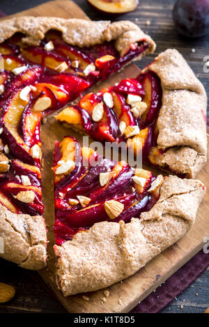 Plum Galette. Tarte aux fruits sains des aliments complets (galette) avec les prunes, les amandes et le sucre brun, végétarien végétalien alimentaire dessert d'automne. Banque D'Images