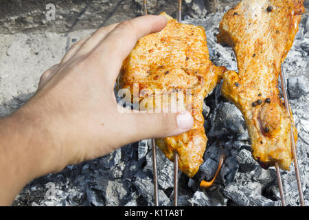 La cuisson des viandes à un pique-nique. La viande de porc étant rôti entier sur une brochette sur feu ouvert. Close-up chachlik macro morceaux de viandes de porc à la broche. Shi Banque D'Images