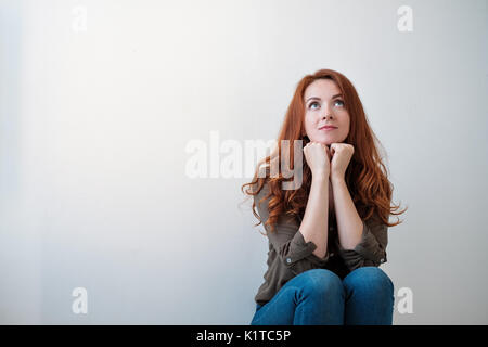 Portrait d'une belle jeune femme pensant, isolé sur fond blanc Banque D'Images