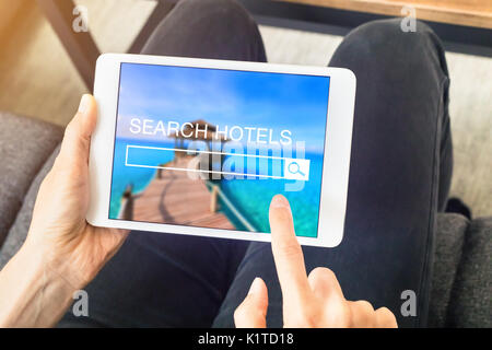 Personne recherchant chambre d'hôtel à réserver en ligne avec un ordinateur tablette et en utilisant un moteur de recherche site Web, planifiez des vacances Banque D'Images